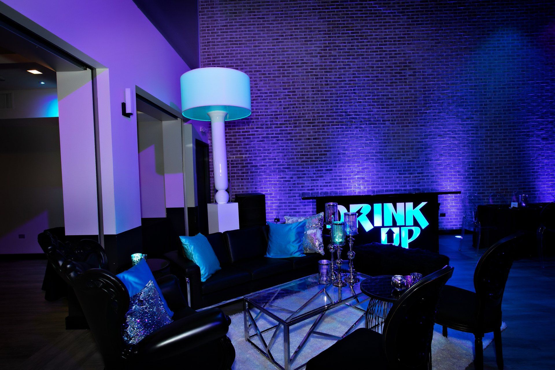 A living room with a couch , table , chairs and a sign that says drink up
