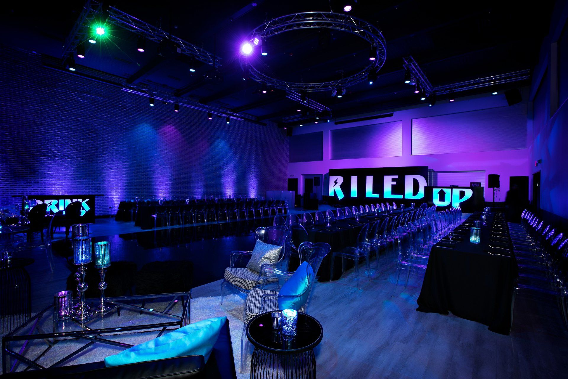A large room with purple lights and a sign that says riled up