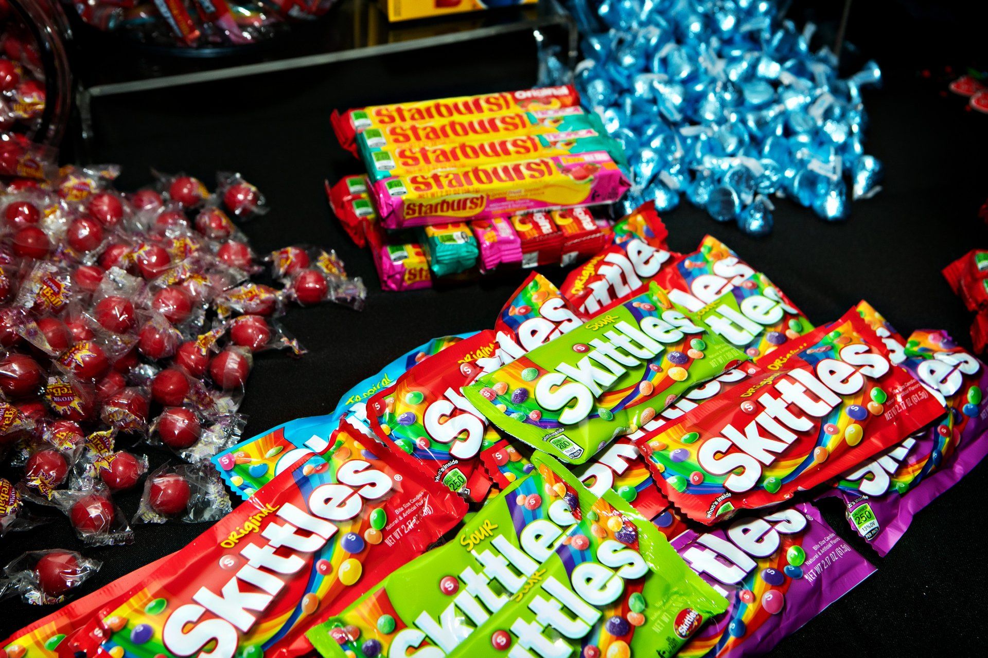 A bunch of skittles are sitting on top of each other on a table.
