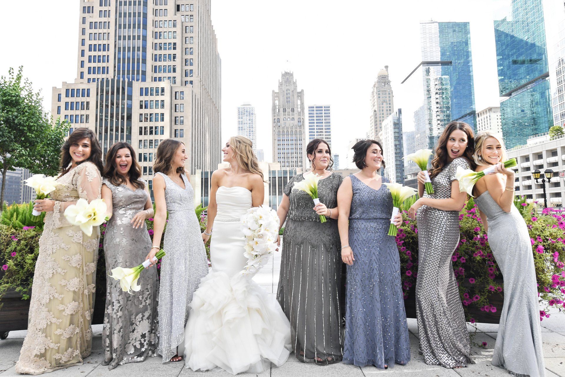 A bride and her bridesmaids are posing for a picture in front of a city skyline.