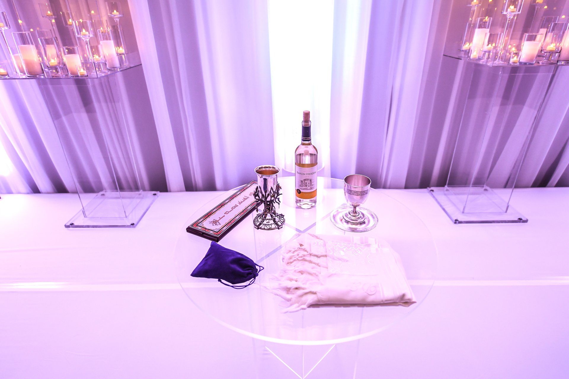 A table with a bottle of vodka and candles on it.