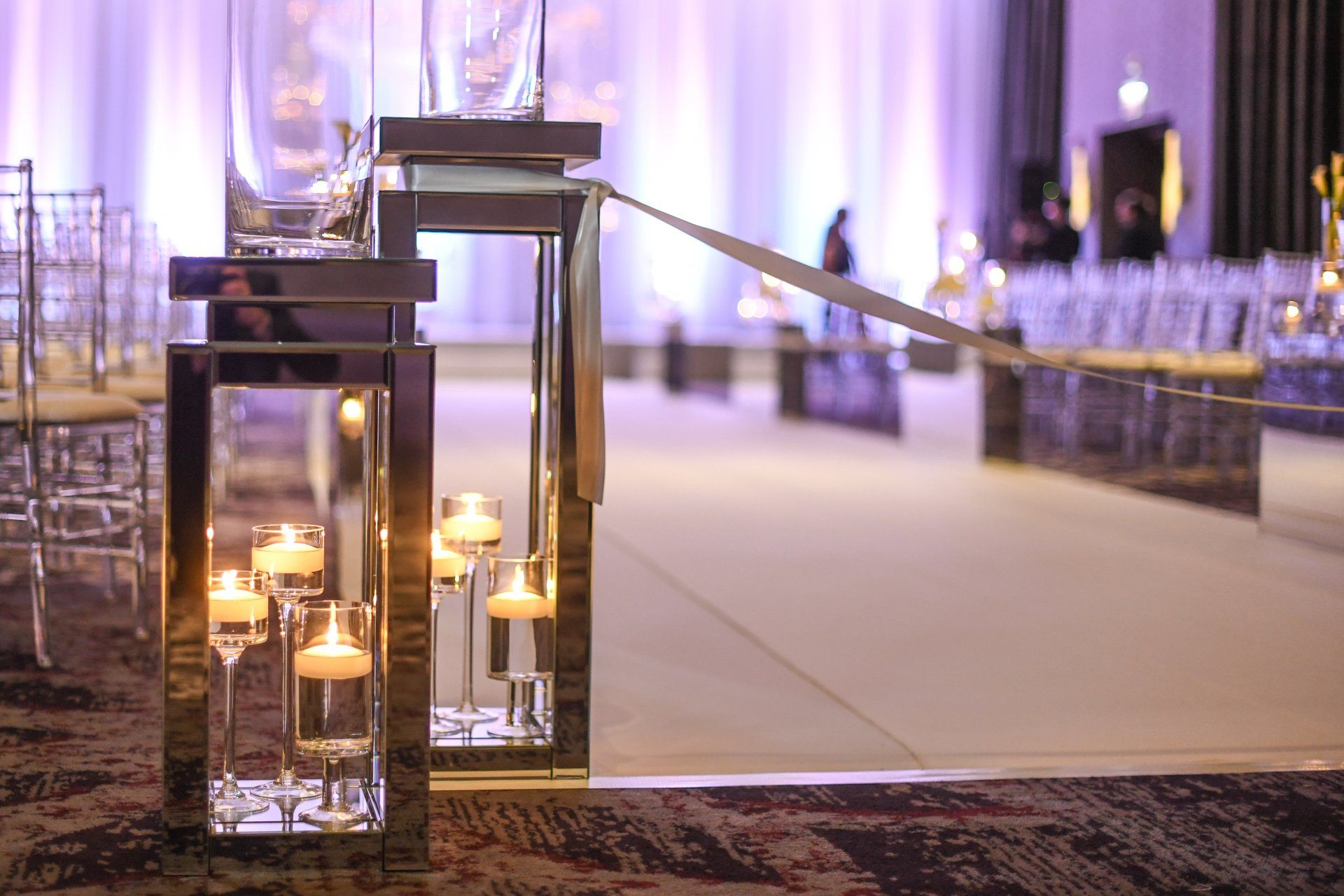A wedding ceremony is taking place in a room with candles on the floor.