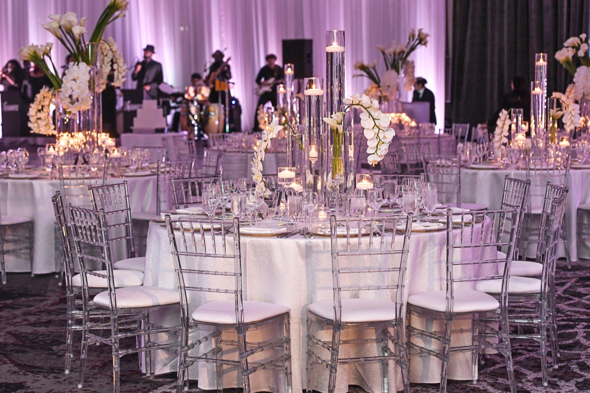 A large room with tables and chairs set up for a wedding reception.