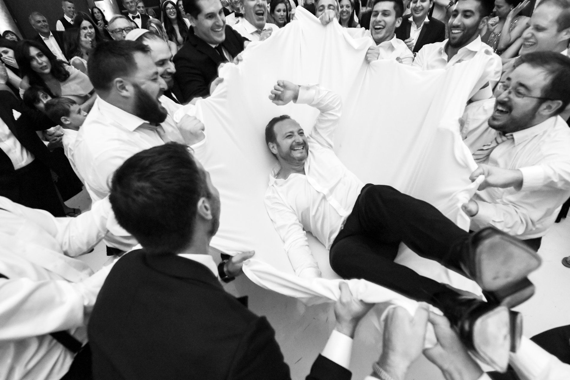 A group of men are holding a man up in the air.