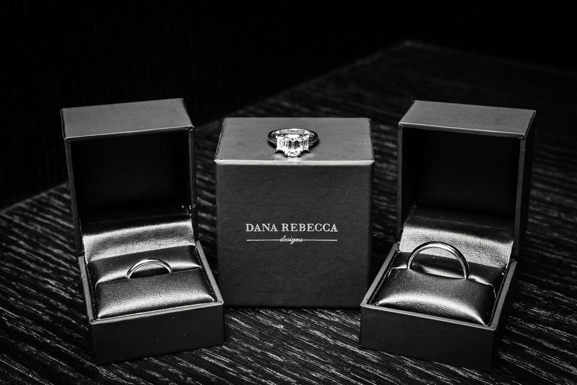 A couple of rings in boxes on a table.