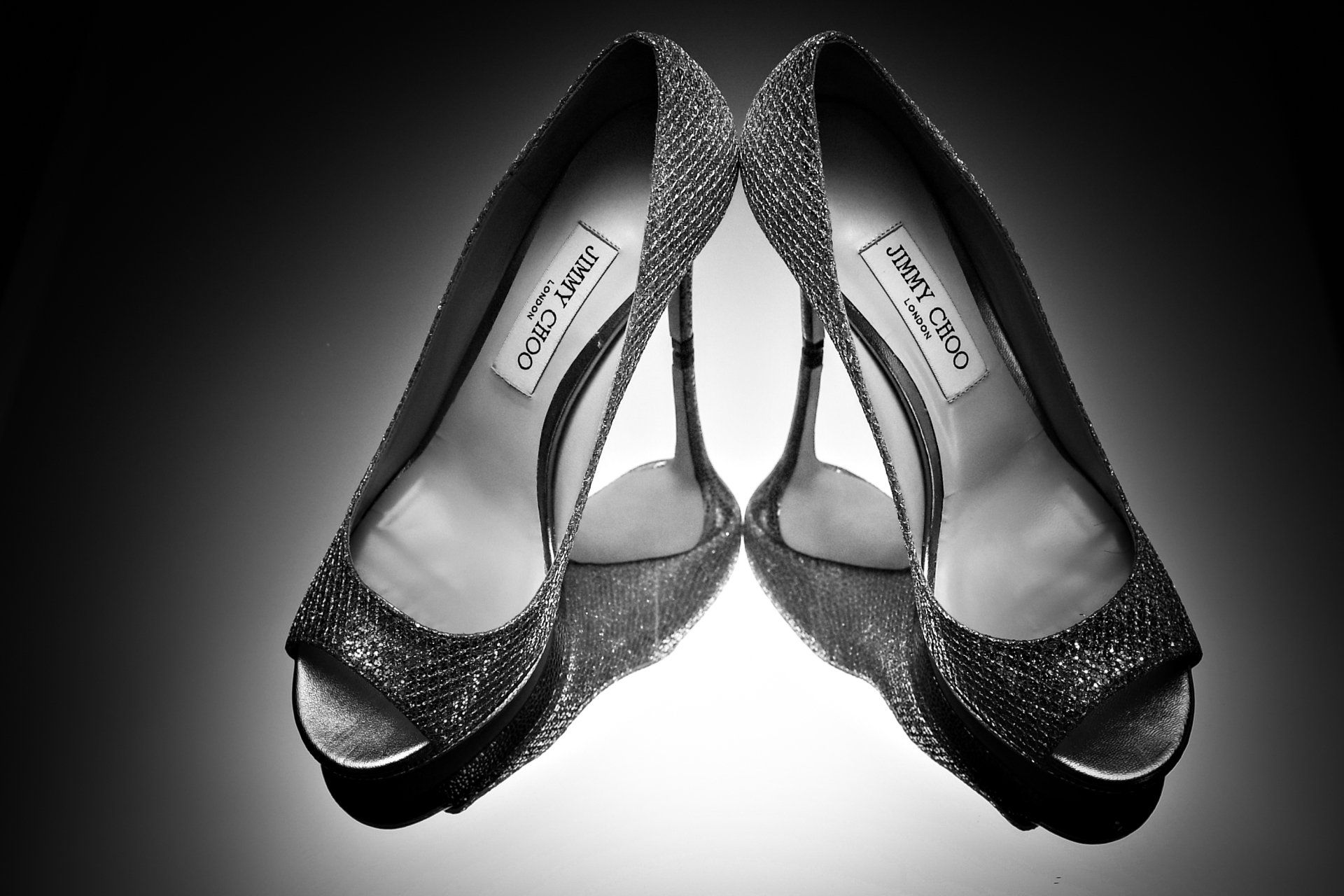 A pair of jimmy choo shoes are shown in a black and white photo