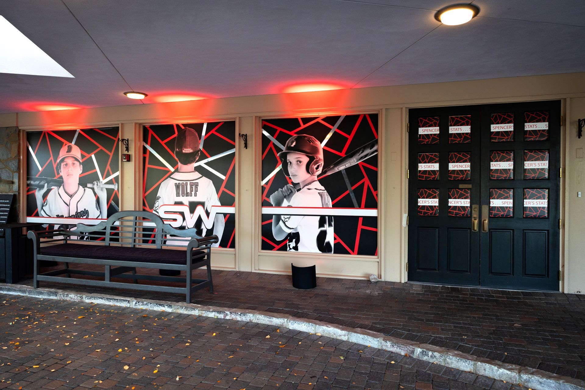 A painting of a baseball player is on the wall of a building.