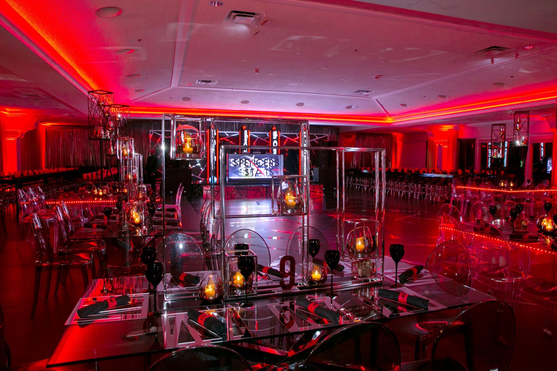 A large room filled with tables and chairs and red lights.