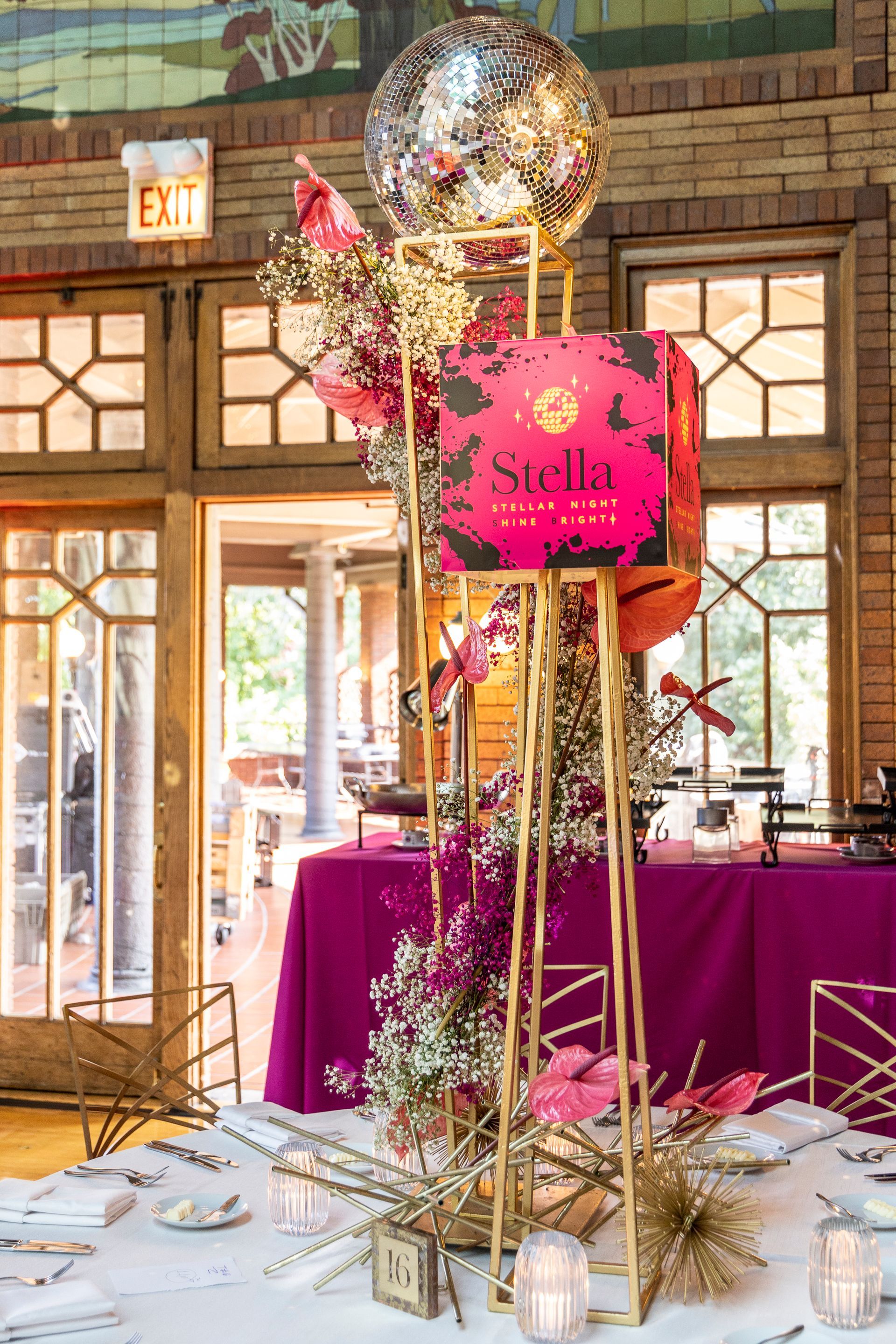A table with a purple table cloth and a balloon on top of it.