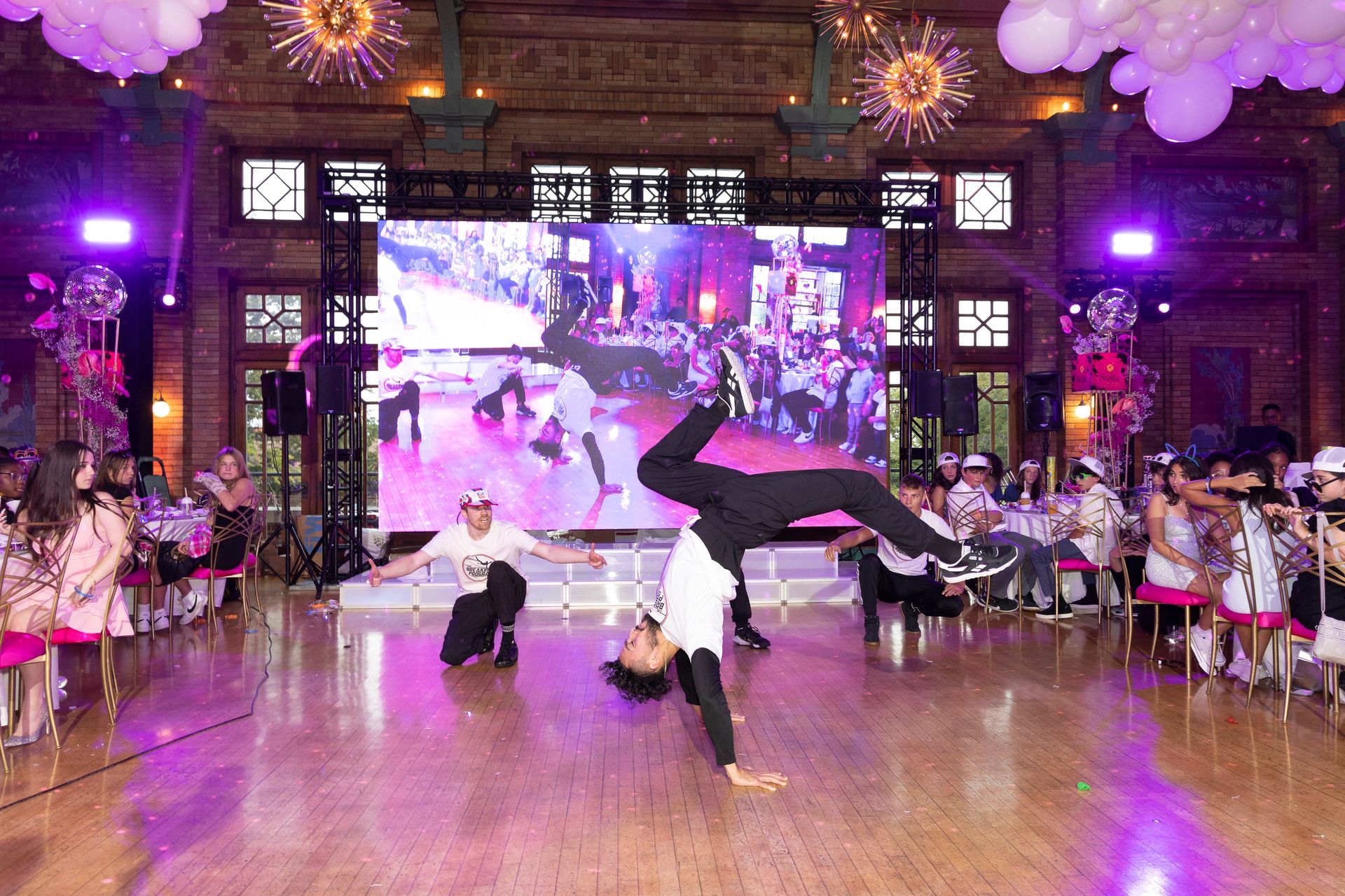 A group of people are doing a handstand on a dance floor.