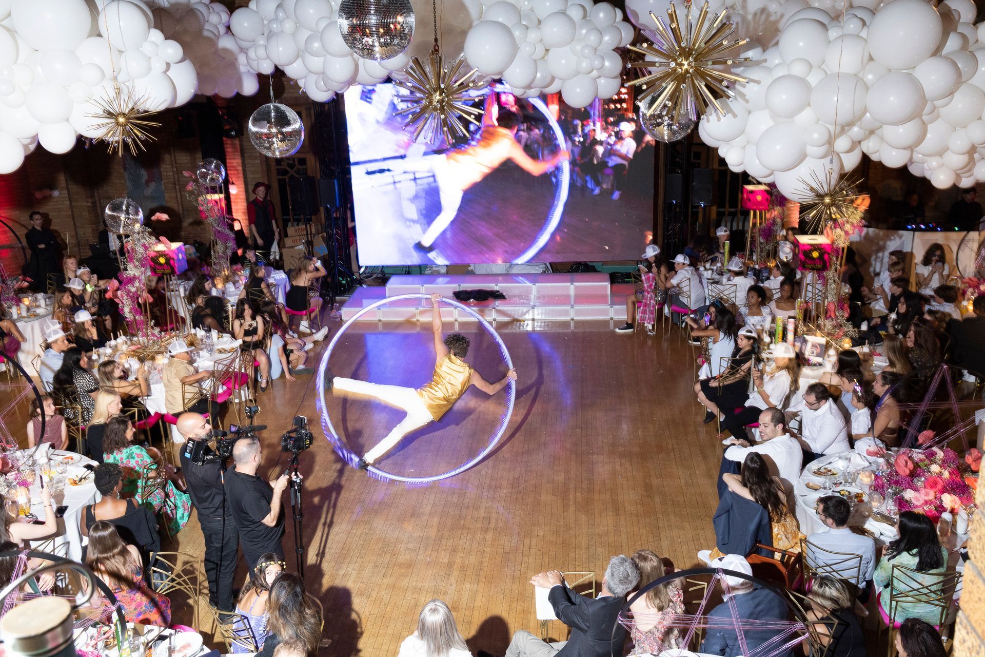Aerial acrobats are performing in front of a crowd at a party.