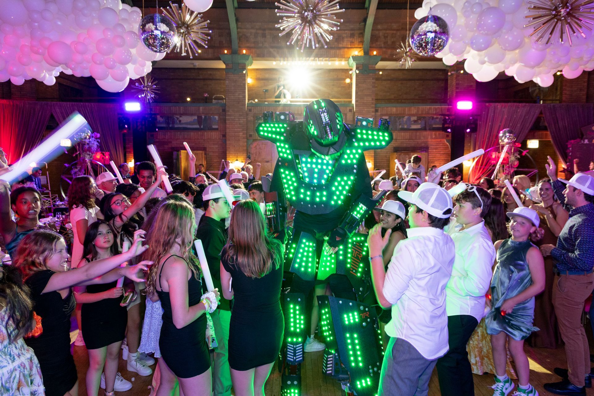 A robot is walking through a crowd of people at a party.