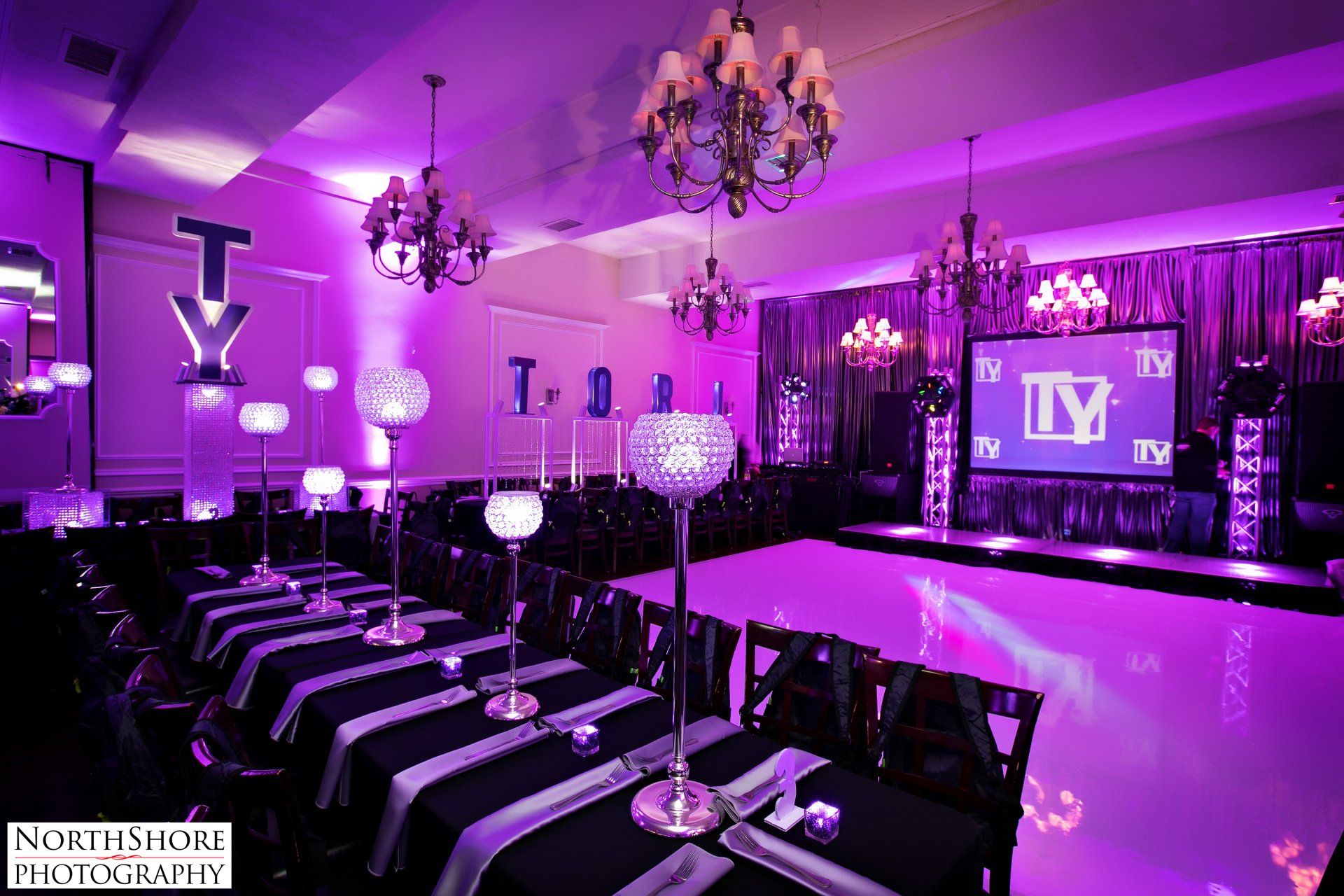 A large room with purple lights and tables and chairs