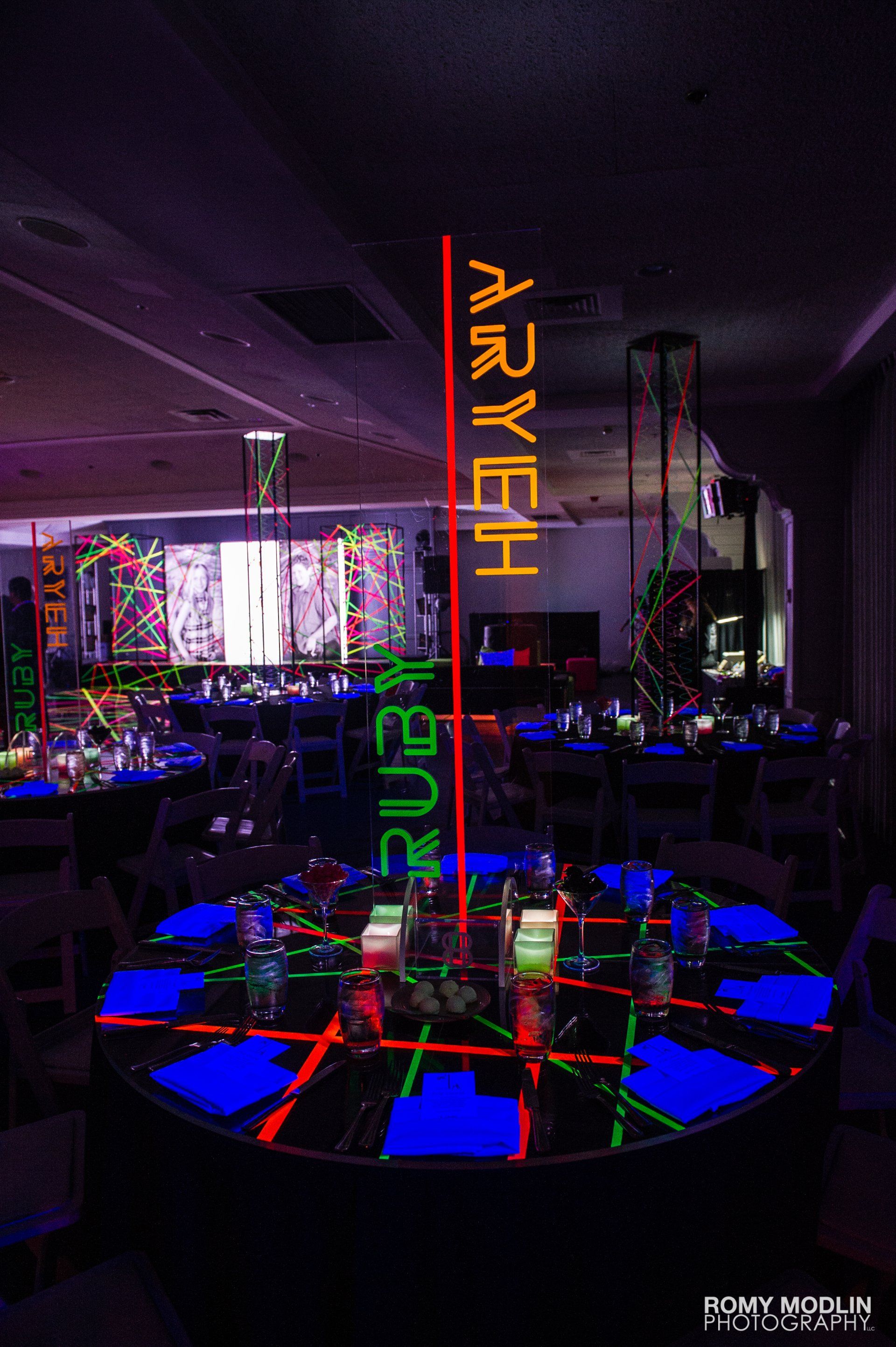 A room filled with tables and chairs with glow in the dark decorations.