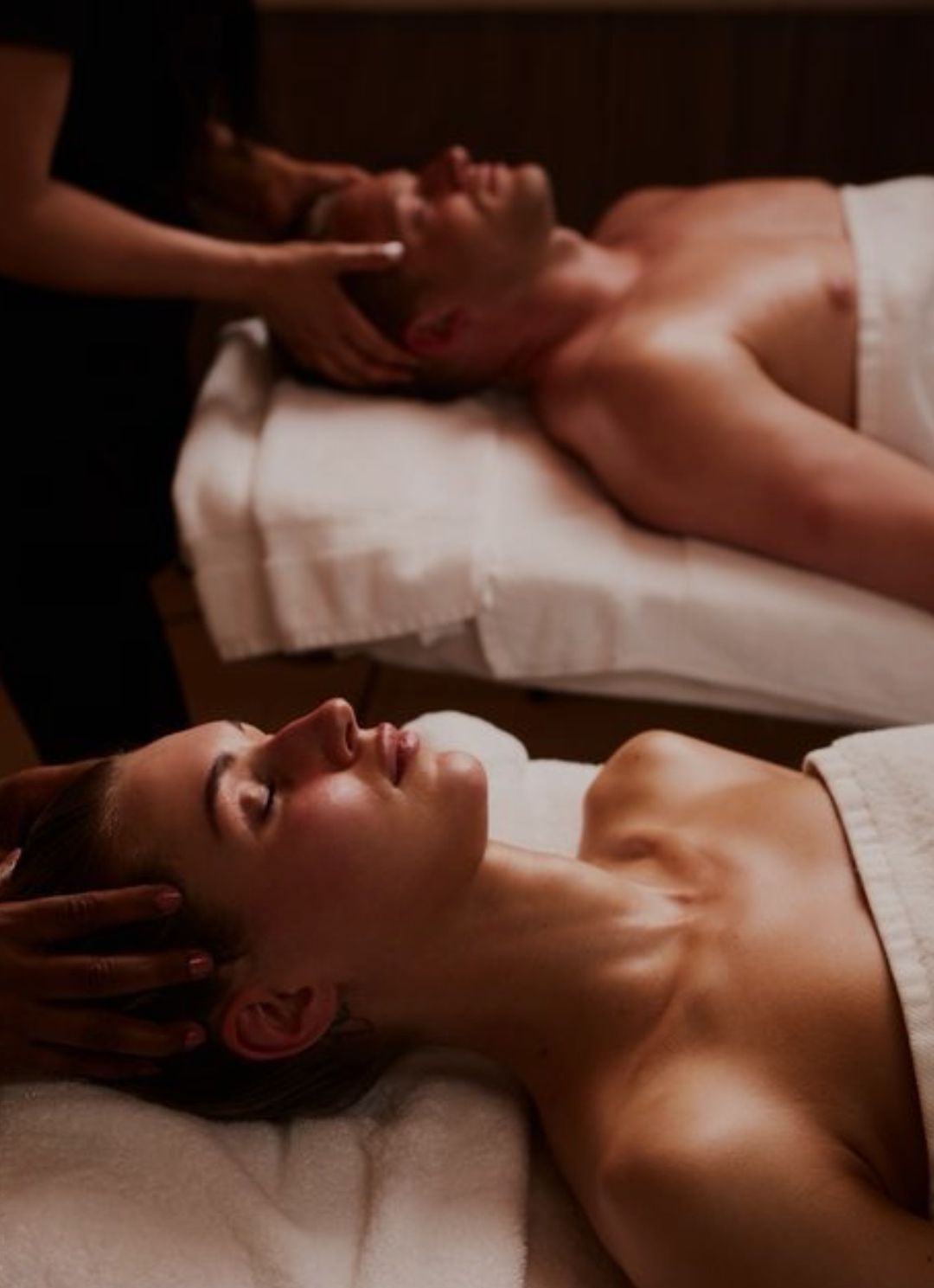 Un hombre y una mujer están recibiendo un masaje en un spa.