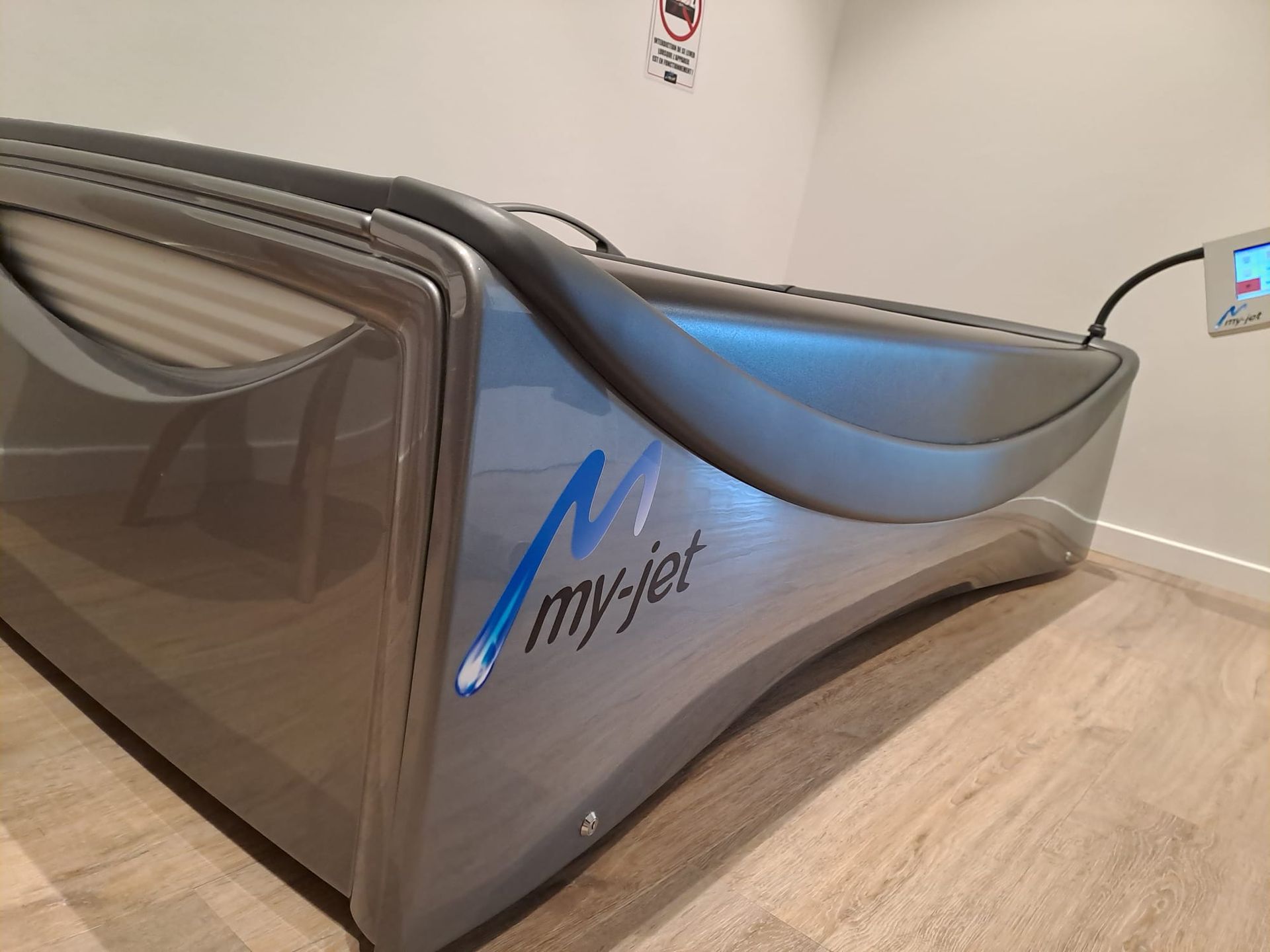 Mon lit de massage à jets est posé sur un plancher en bois dans une pièce.