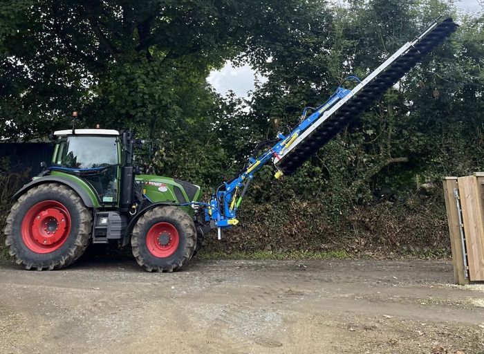 a tractor is cleaning solar panels with a machine .