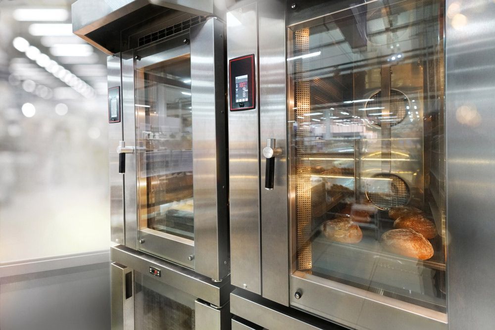 A Row of Commercial Ovens With Bread in Them in a Bakery — Commercial Kitchens Direct in Shoalhaven, NSW