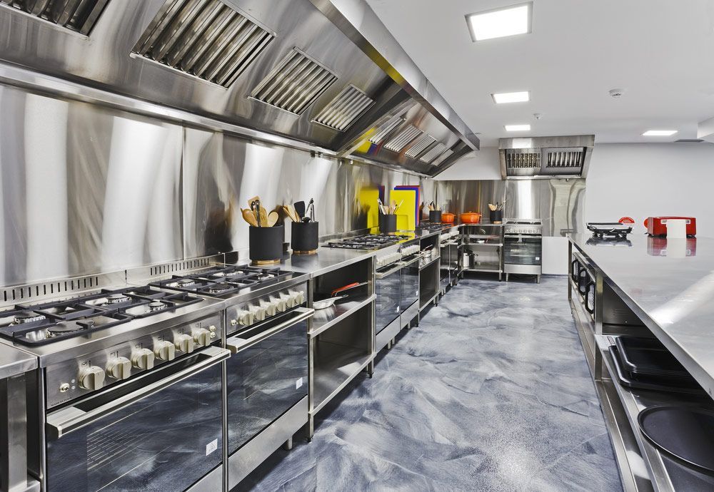 A Large Kitchen With a Lot of Stainless Steel Appliances — Commercial Kitchens Direct in Unanderra, NSW