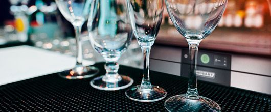 A Row of Wine Glasses Sitting on Top of a Bar Mat — Commercial Kitchens Direct in Shellharbour, NSW