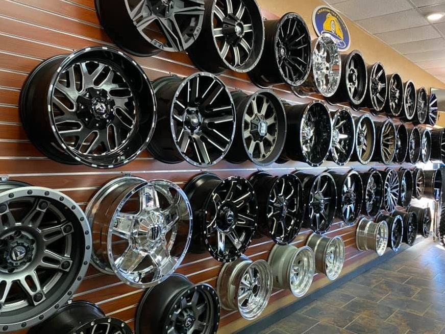 A showroom wall filled with a variety of wheels and tires