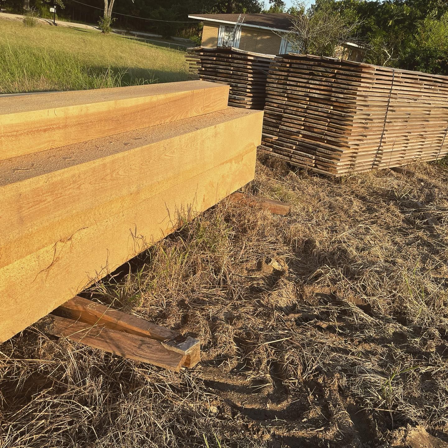A pile of wood is sitting on the ground in a field