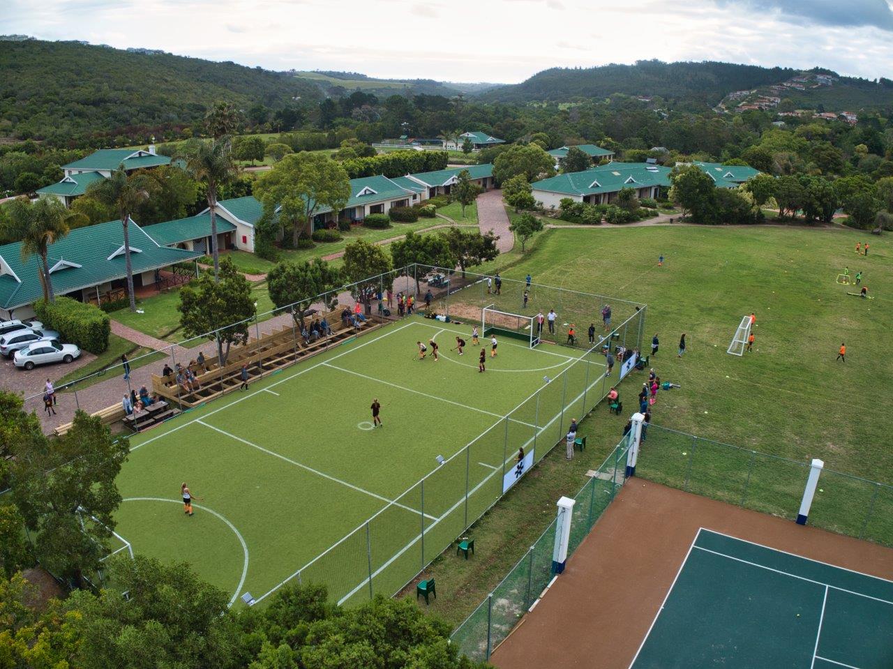 an aerial view of a tennis court and soccer field