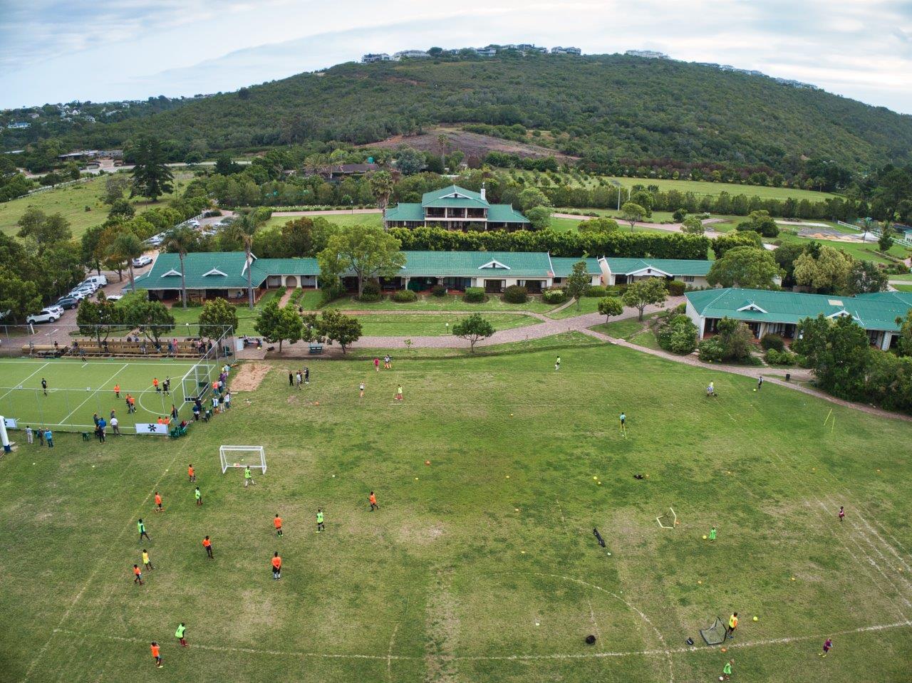 an aerial view of a soccer field with a building in the background
