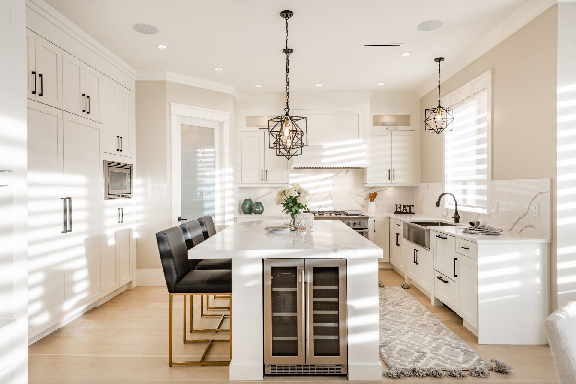 A kitchen with white cabinets and a large island in the middle.