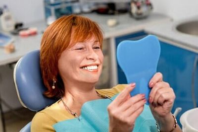 Patient looking at clean teeth - Dental Implants in Newport News, VA
