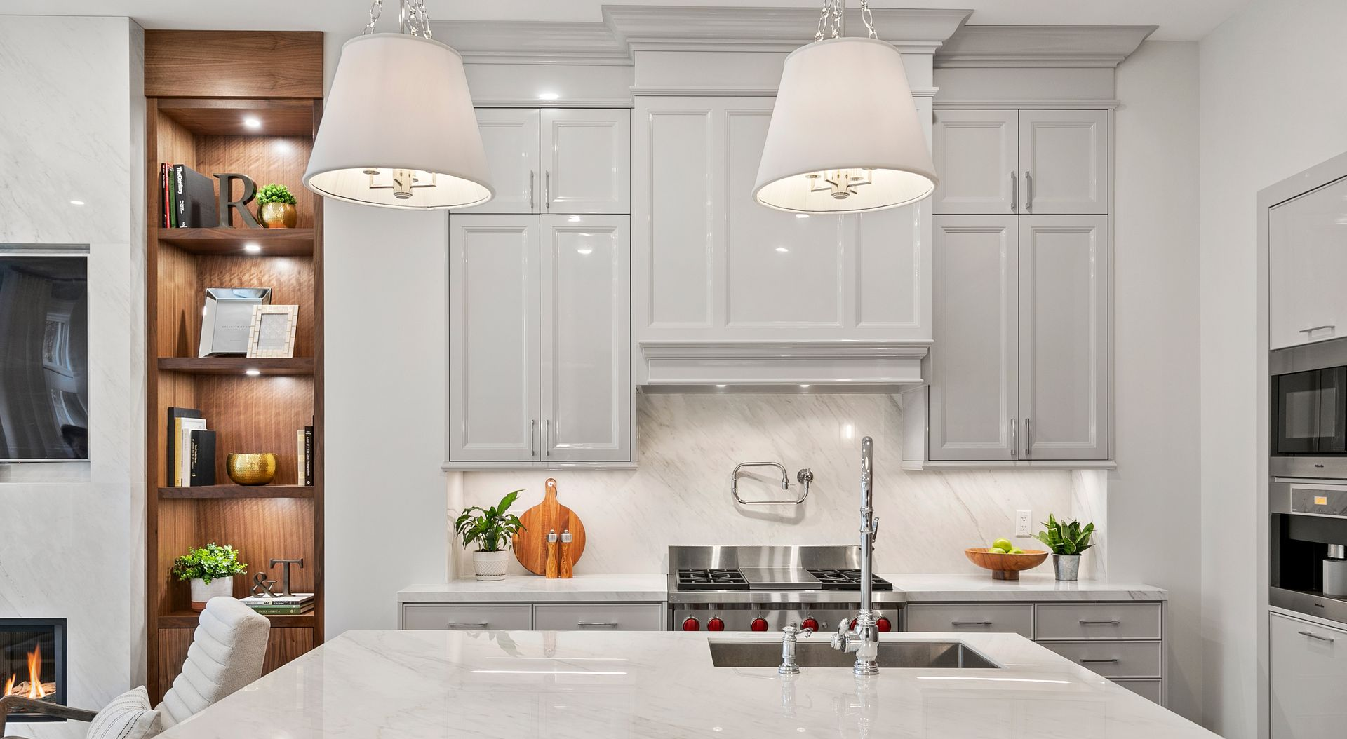 Kitchen with gray cabinets, white countertops, and two pendant lights.