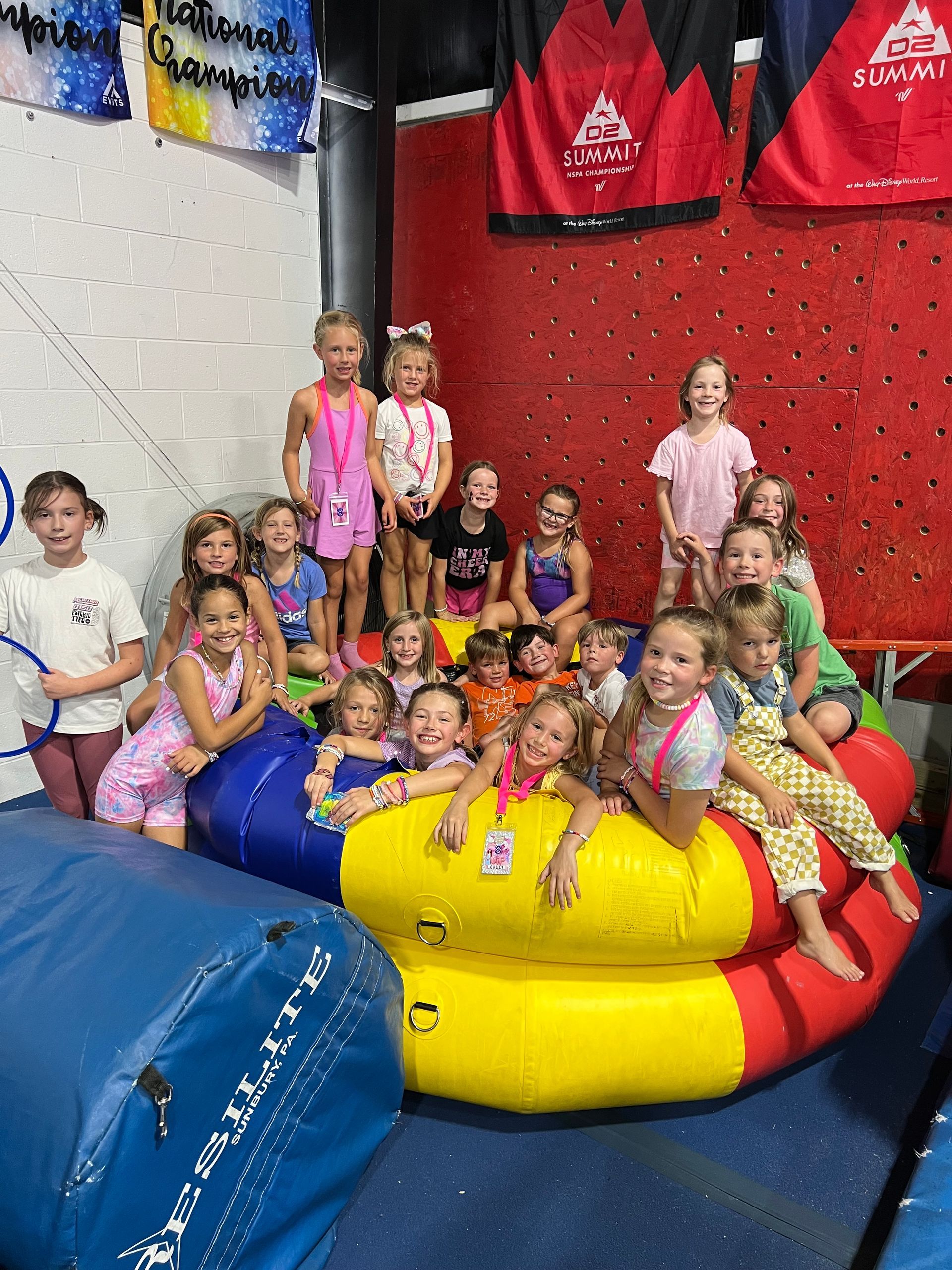 Children lying on floor, laughing, reaching for colorful confetti falling during a celebration.