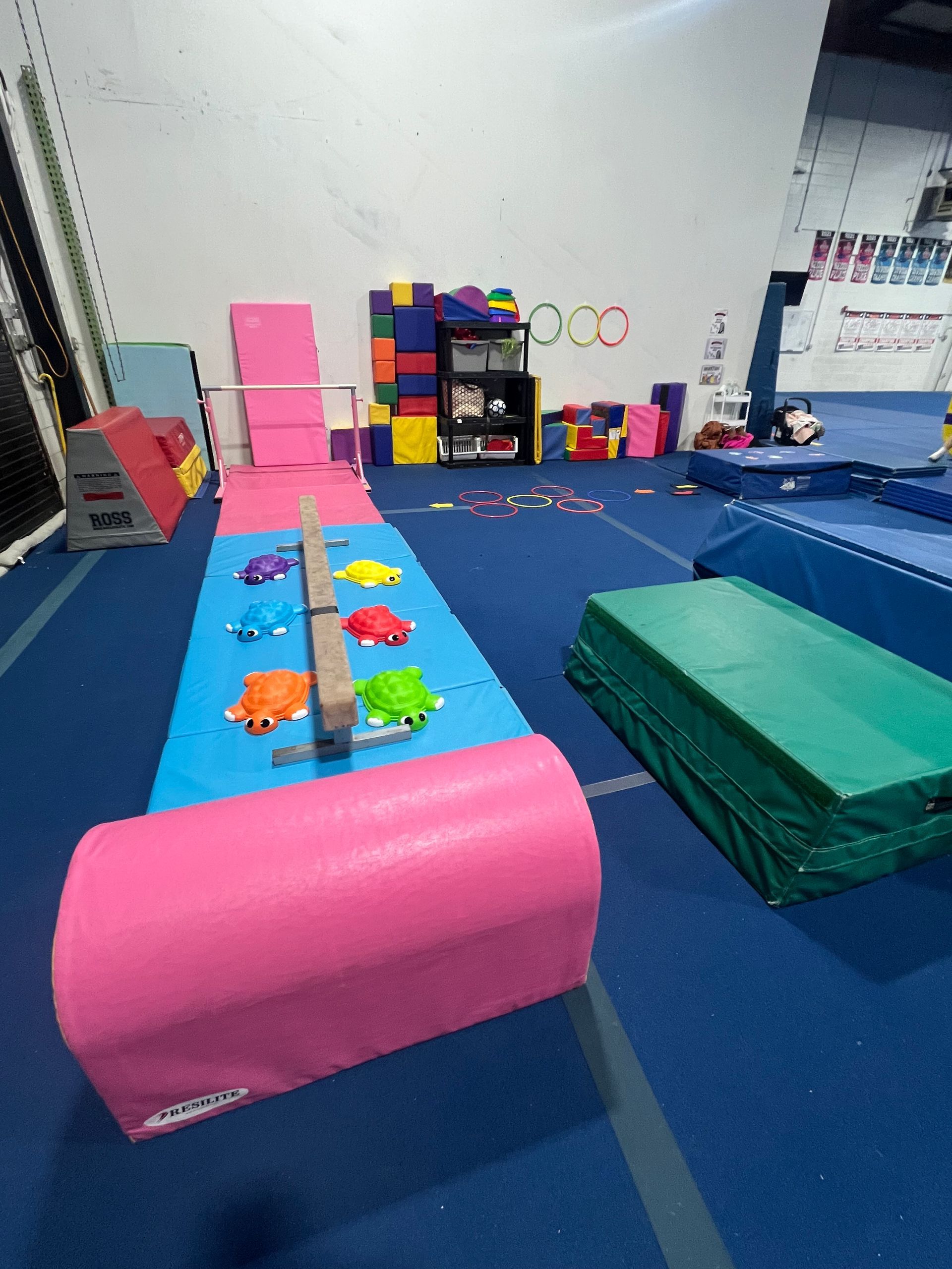 A gym filled with lots of toys and a balance beam.