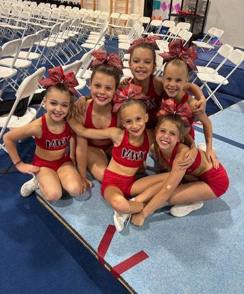 A group of cheerleaders are posing for a picture together