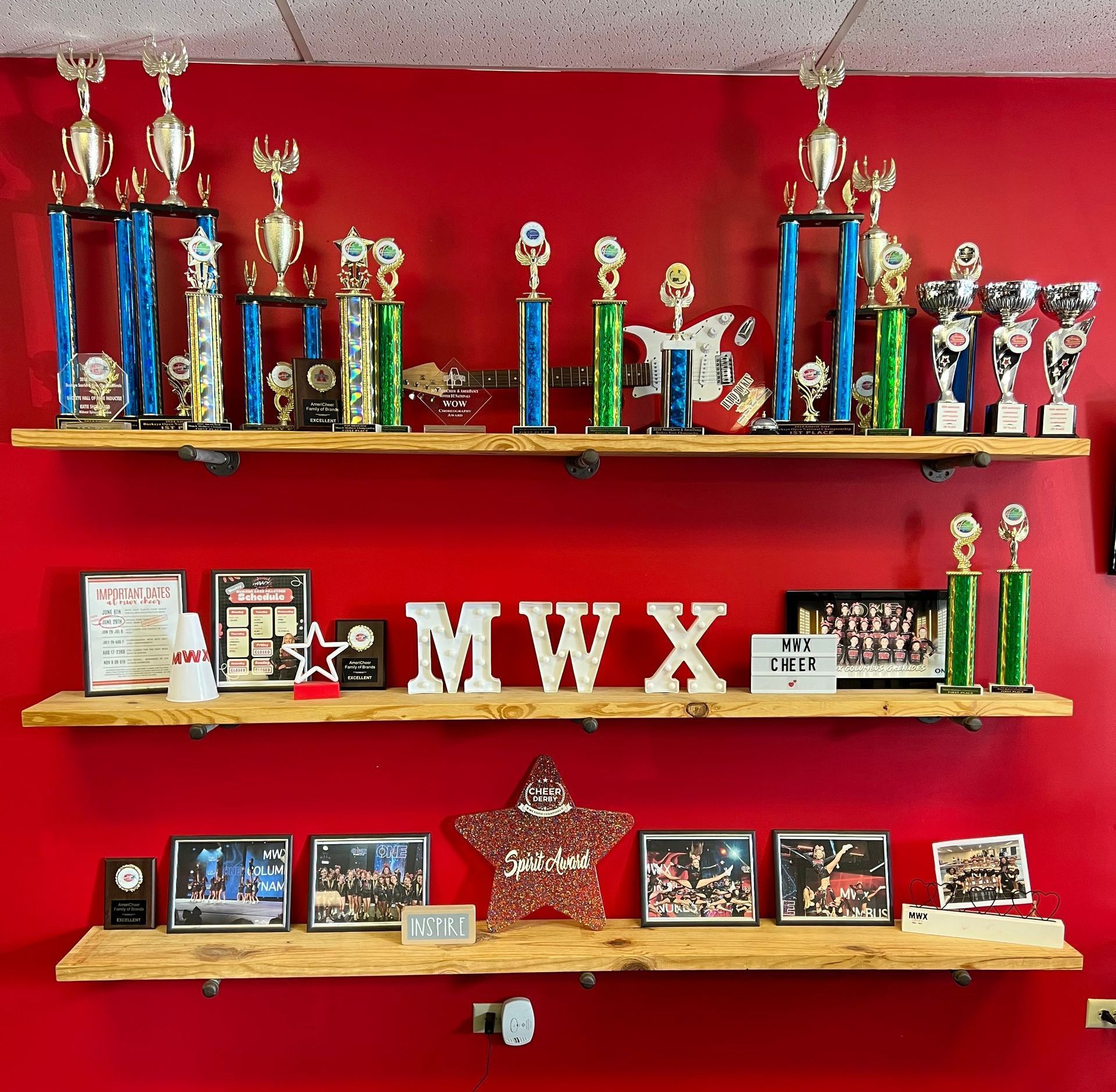 Shelves filled with trophies and a sign that says mwx on it
