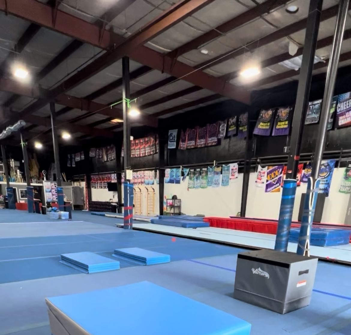 A gym with blue mats and a box that says ' agility ' on it