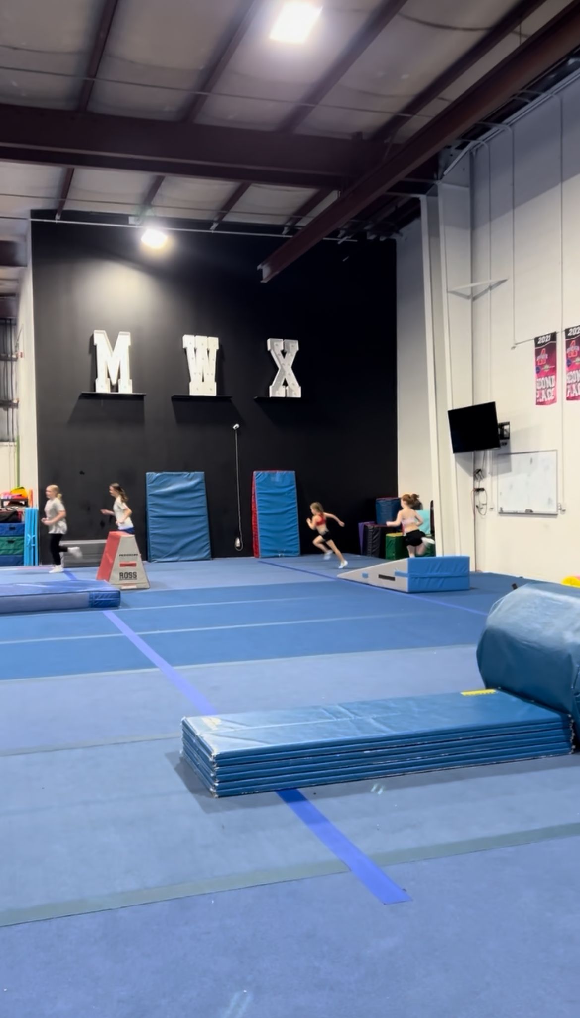 A gym filled with blue mats and foam blocks.