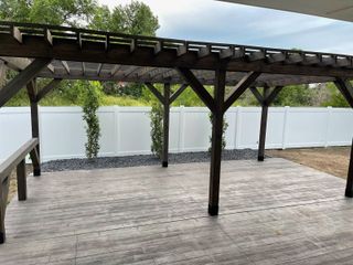 A wooden pergola is sitting on top of a wooden deck.