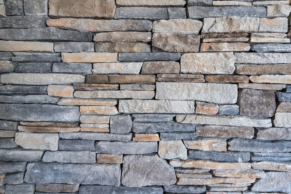 A close up of a stone wall made of different types of rocks.