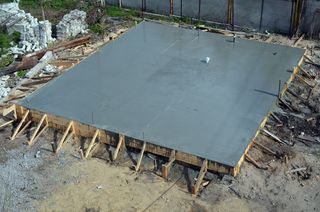 A large concrete slab is sitting on top of a dirt field.