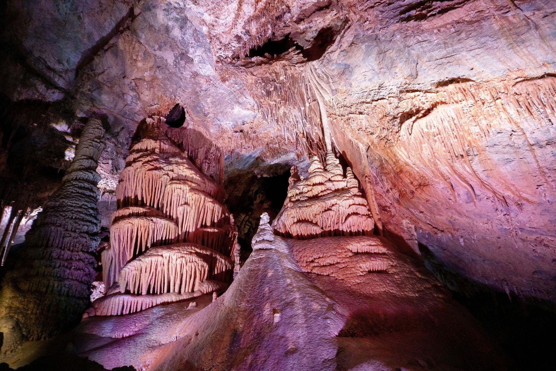 Cave interior with colorful rock formations, including stalactites and stalagmites.