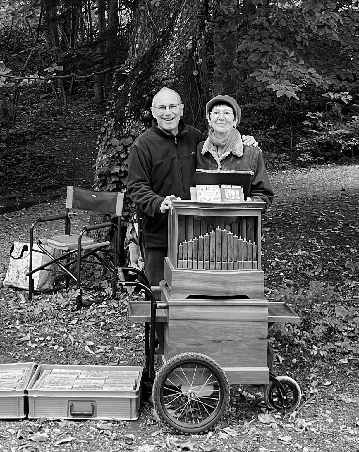 Een zwart-witfoto van twee mannen die naast een houten orgel staan.