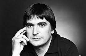 Een zwart-witfoto van een man met zijn hand op zijn kin.