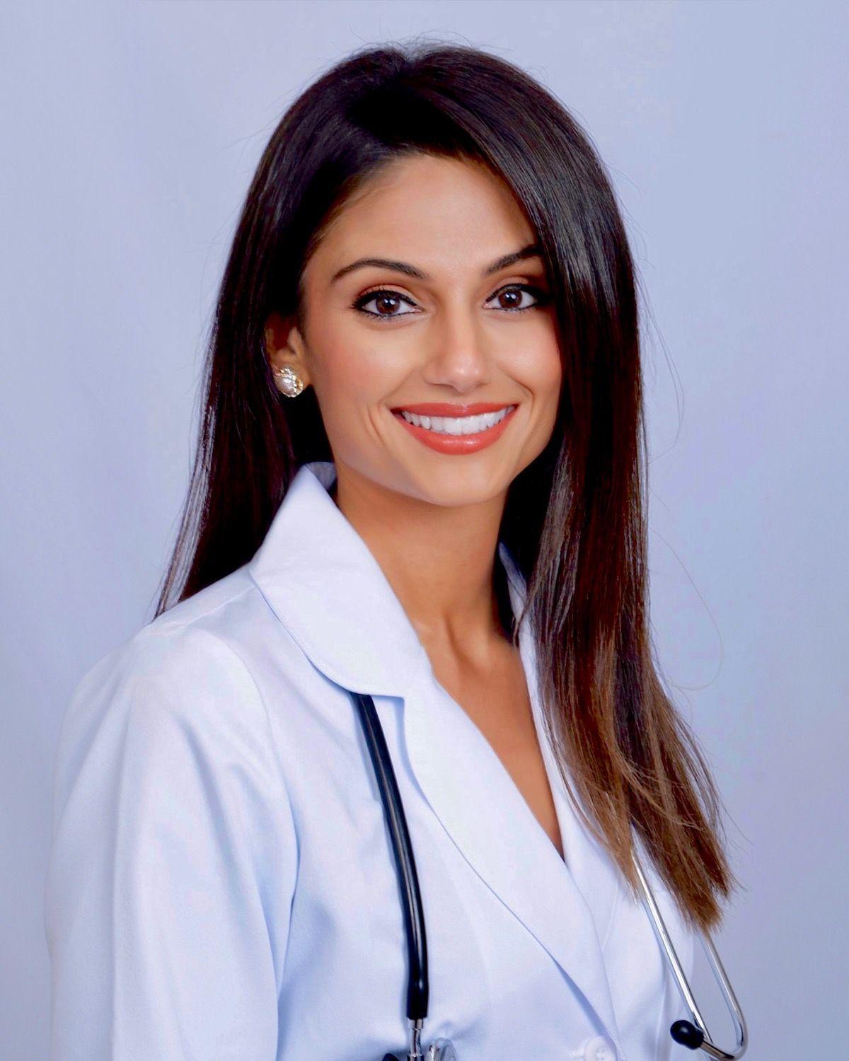 A woman in a white coat with a stethoscope around her neck