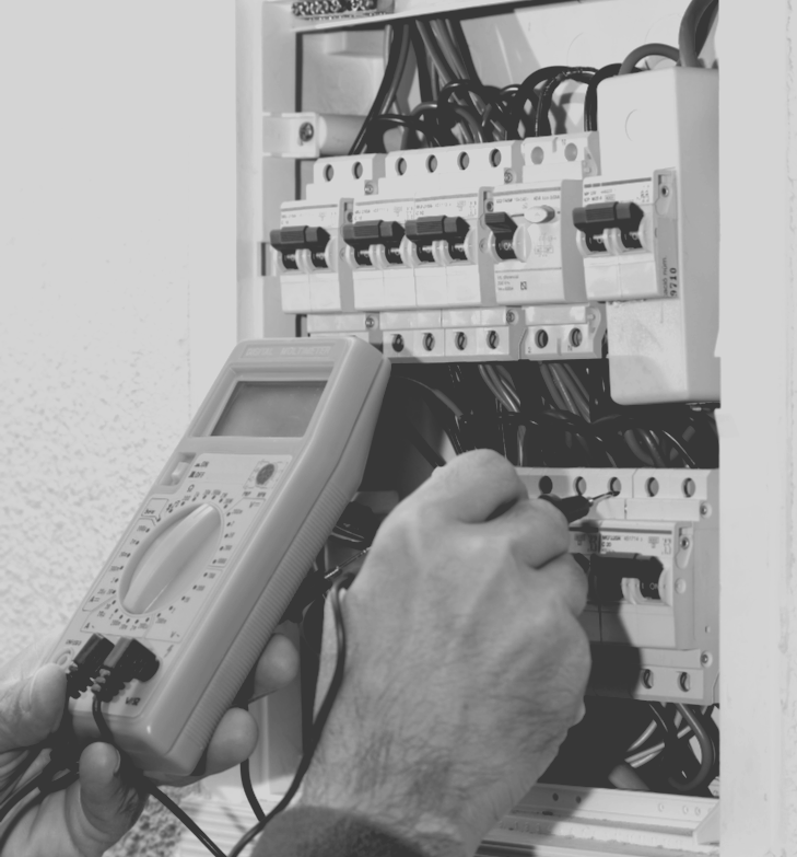 A black and white photo of a person using a multimeter