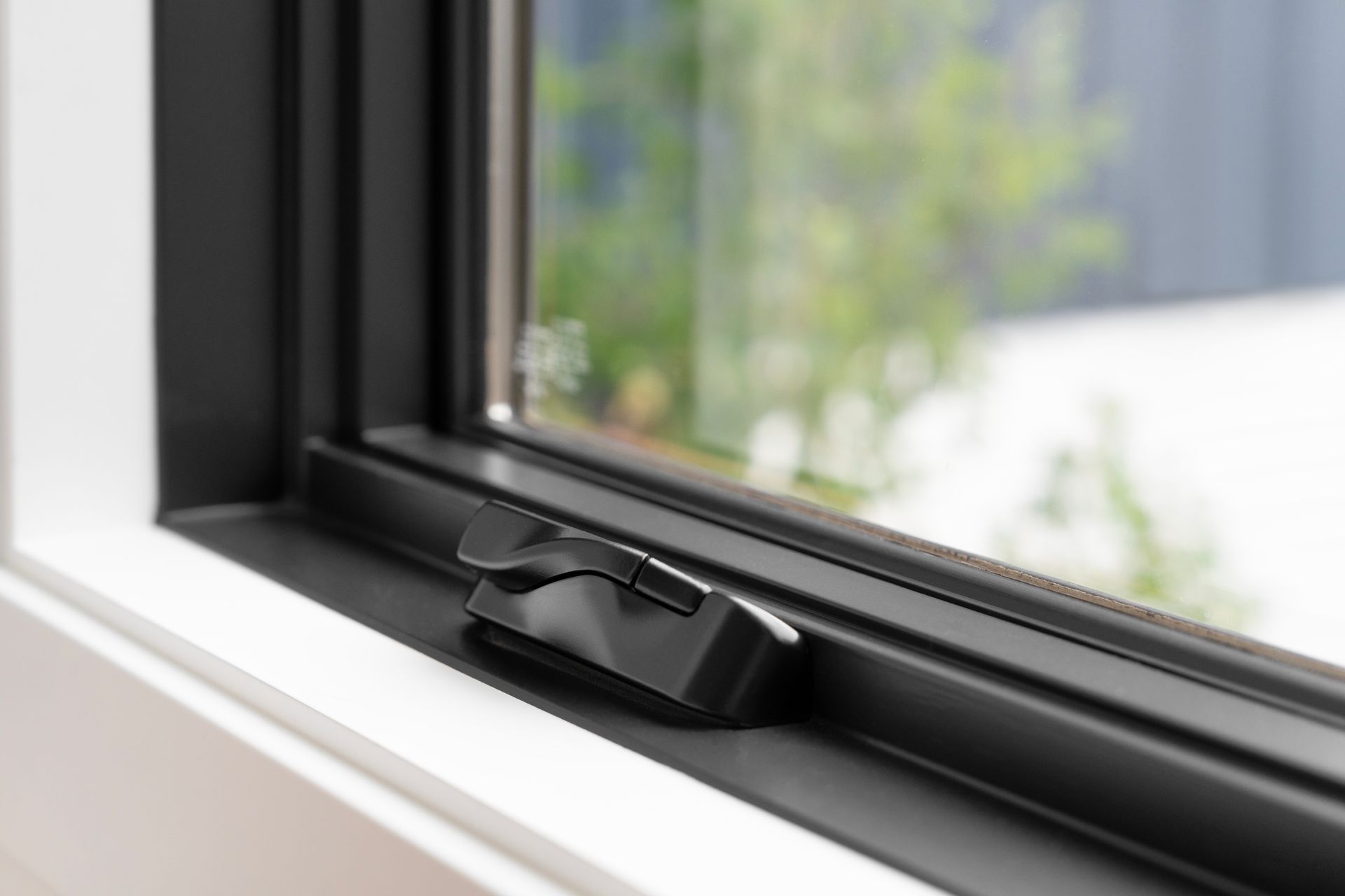 A close up of a black window with a lock on it.