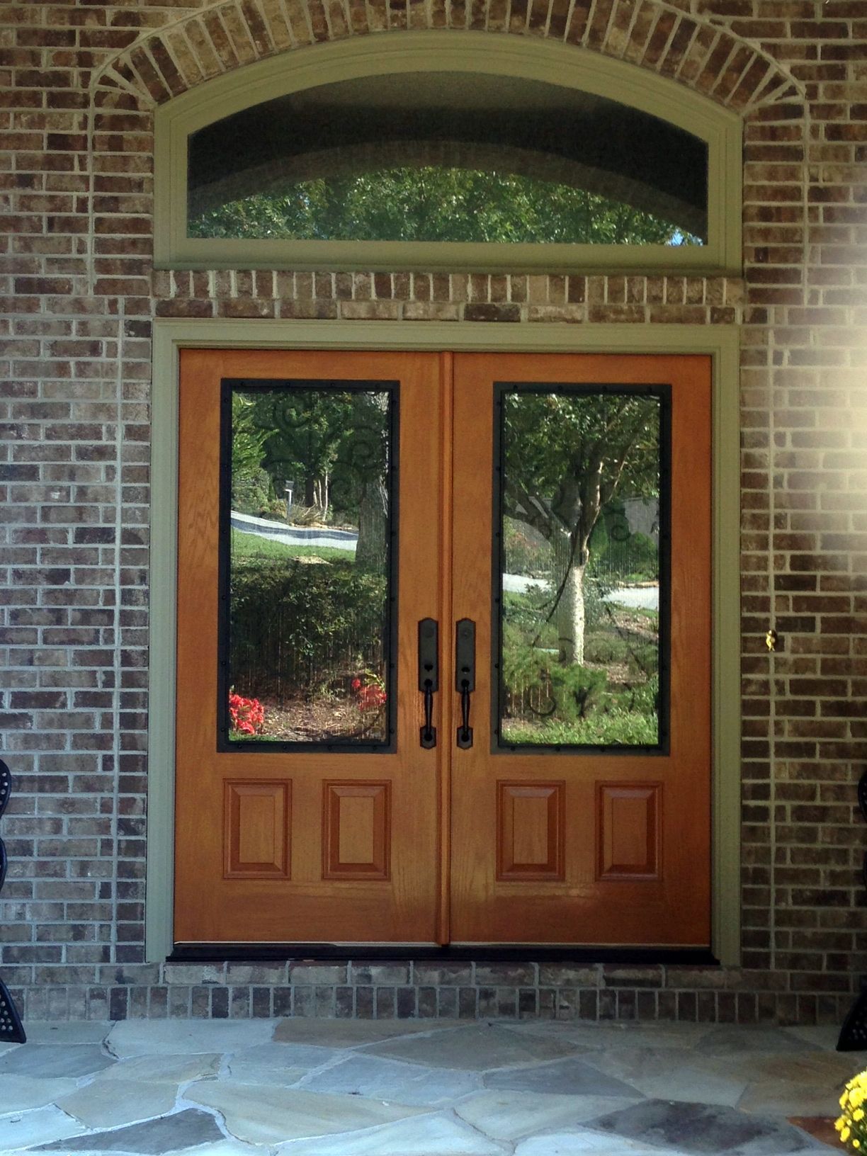 A brick building with a pair of wooden doors