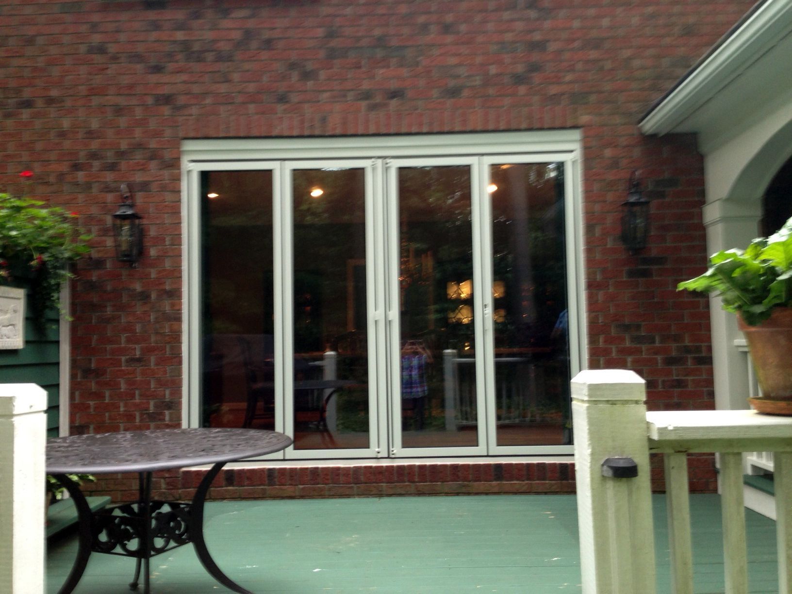 A patio with a table and chairs in front of a brick building