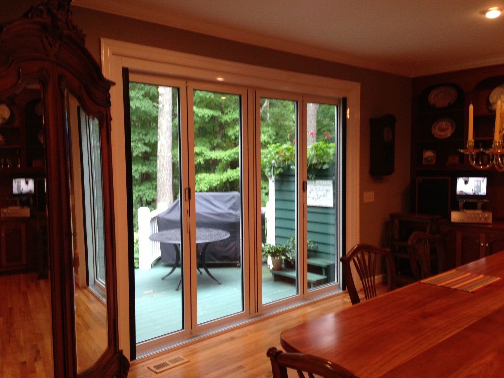 A dining room with a table and chairs and sliding glass doors
