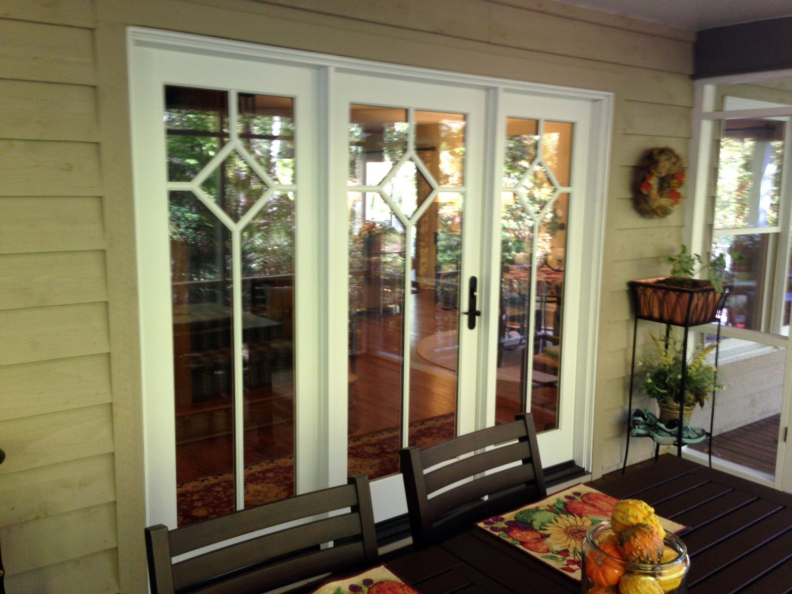 A patio with a table and chairs and sliding glass doors